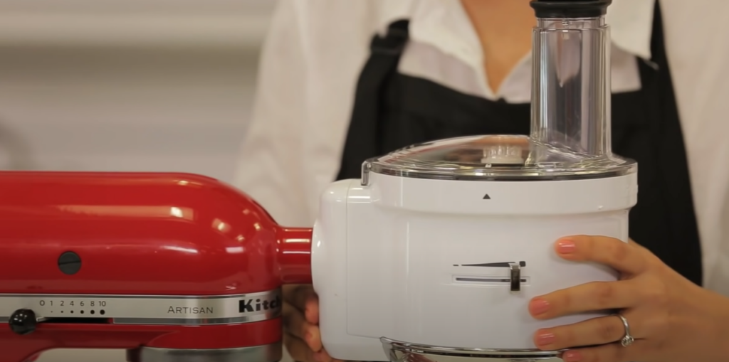 Woman's hand holding KitchenAid Food Processor Attachment