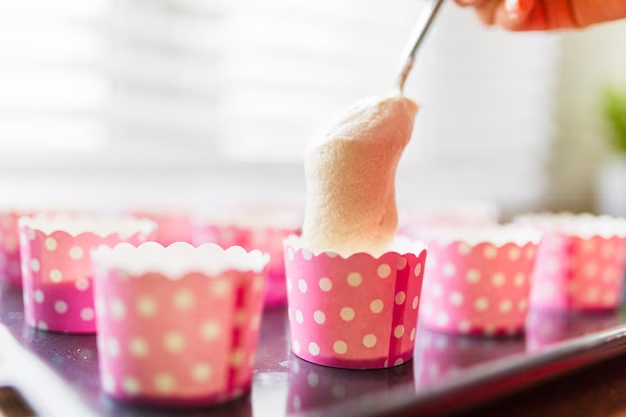 Pouring cake batter into pink cups