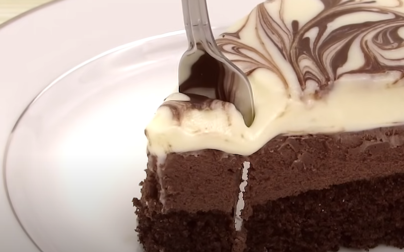 A closed up shot of a Black Tie Mousse Cake, being sliced by a fork